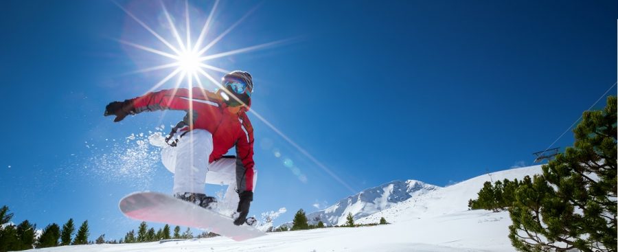 Snowboarder die in de zon aan het snowboarden is