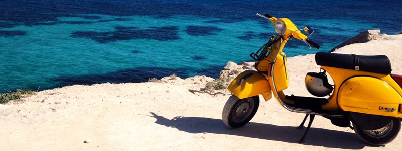 Zomervakantie Le Marche Gele scooter bij een zandstrand in Le Marche