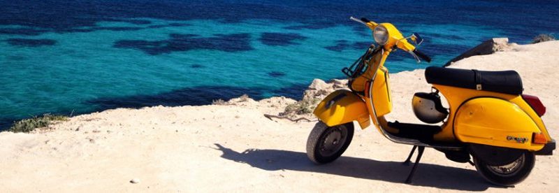 Gele scooter bij een zandstrand in Le Marche
