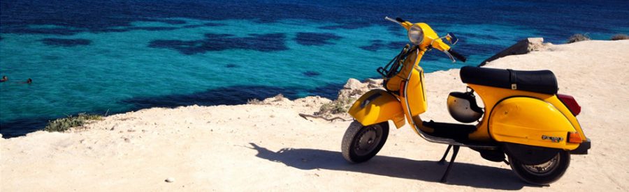 Gele scooter bij een zandstrand in Le Marche